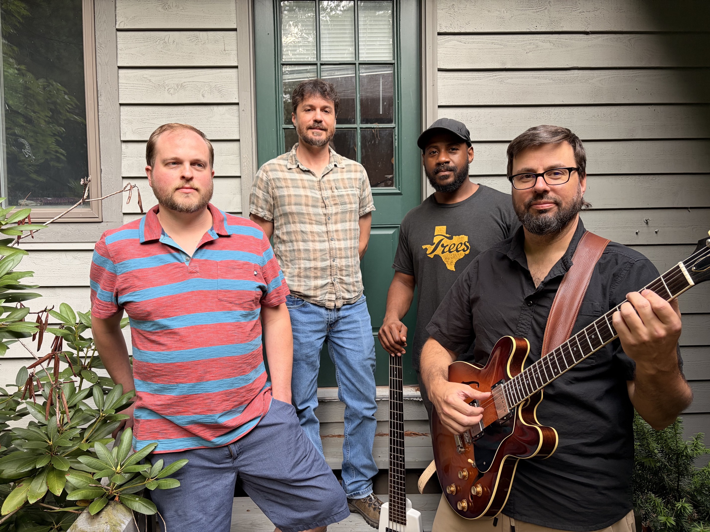 The four members of Wrealist on a porch, Ken holding his electric guitar